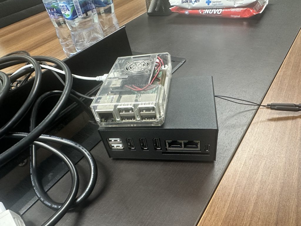 A photo on an office meeting desk featuring a Raspberry Pi 3B stacked above the new Orange Pi 5 Plus.